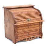 A miniature oak table top roll-top desk stamp box, the tambour top enclosing a fitted interior above