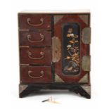 A late 19th century Japanese lacquer table top cabinet with four short drawers and a cupboard,