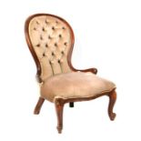 A stained beech button back upholstered nursing chair.