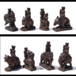 A group of Balinese carved wooden figures depicting riders on mythical beasts and elephants, the