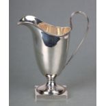 A silver helmet shaped milk jug on square base, Chester 1922, 12.5cms high, 86g.