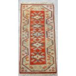 A Persian hand knotted woollen runner with stylised tulip design within geometric borders, on a