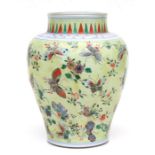 A Chinese famille rose baluster vase decorated with butterflies on a pale yellow ground, 26cms
