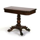 A Victorian figured mahogany tea table on turned column and quatrefoil base with lion paw feet,