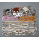 A quantity of costume jewellery to include necklaces and brooches.