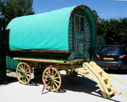 An early 20th century gypsy bowtop horses-drawn wagon with traditional painted decoration and fitted