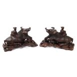 A pair of Chinese hardwood groups depicting a young child riding on the back of a water buffalo,