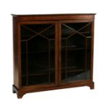 An Edwardian inlaid mahogany bookcase, the pair of glazed doors enclosing a shelved interior, on