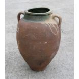 A large Mediterranean terracotta two-handled olive jar with green glazed banded rim, 55cms high.