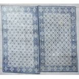 A Persian hand knotted blue & cream woollen rug with repeated floral medallions, 212 by 121cms;