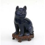 A Chinese blue glazed pottery cat on a hardwood stand, 19cms high (a/f)Condition ReportRe-glued