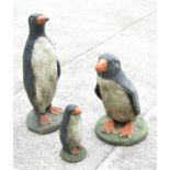 A group of painted stoneware garden penguins, the largest 67cms high (3).