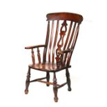 A late Victorian beech and elm farmhouse kitchen armchair with turned front legs joined by