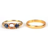 A 22ct gold wedding band, 2g; together with an 18ct gold ring set two sapphires (missing central