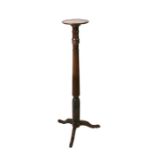 An Edwardian mahogany torchere on reeded column and tripod base.