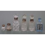 A small collection of Victorian and later cut glass and silver topped scent bottles.