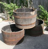 Three metal bound half barrel planters, 65cms diameter (a/f) (3).
