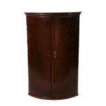 A 19th century mahogany bowfronted corner cupboard, 64cms wide.