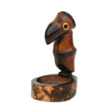 An Art Deco wood and bamboo novelty ashtray in the form of a bird with a cherry amber Bakelite beak,