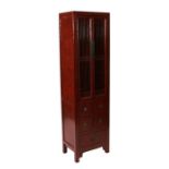 A Chinese red lacquer food cupboard of narrow proportions with two grille doors enclosing shelves