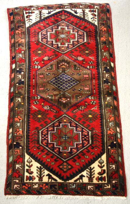 A Persian Hamadan hand knotted woollen rug with stylised design within borders, on a red ground, 163