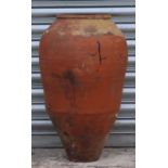 A terracotta olive jar of tapering cylindrical form, 62cms high.
