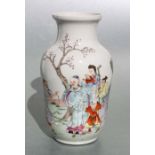 A Chinese famille rose vase, decorated figures in a landscape, 21cm high
