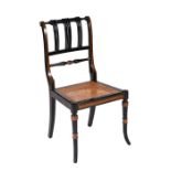 A Regency style ebonised chair with turned back rail, cane seat and ring turned tapering splayed