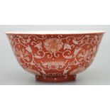 A Chinese footed bowl decorated with scrolling flowering foliage on a burnt orange ground, six