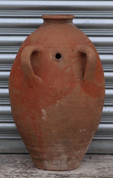A two-handled terracotta olive jar with banded decoration, of tapering cylindrical form, 71cms high.