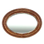 A Victorian style gilt gesso oval wall mirror with bevelled plate, 95cms wide.