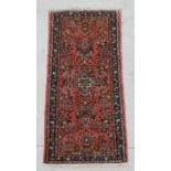 A Persian runner with floral repeating motifs on a pink ground within a multi border, 189 by 67cms.