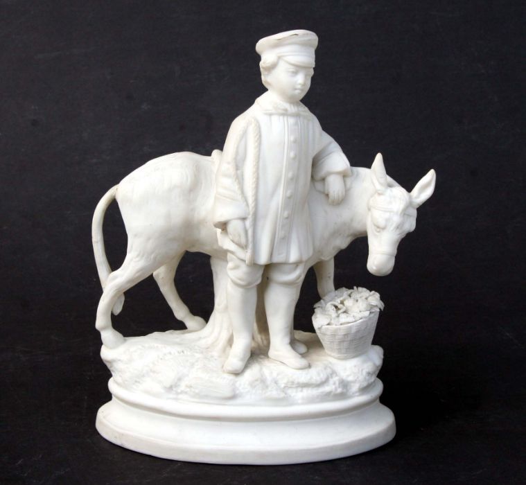 A 19th century continental Parian group depicting a young boy with his donkey and a basket of