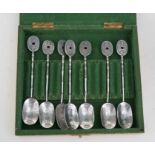 A set of seven Japanese ornate silver tea or coffee spoons, cased.