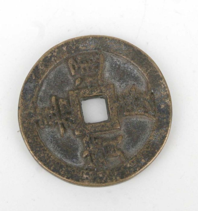 A Chinese bronze coin / pierced disc with four character mark to the underside, 6.5cm diameter