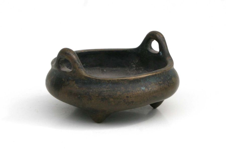 A Chinese bronze two handled tripod censor with impressed six character mark to the underside,