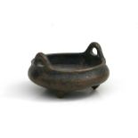 A Chinese bronze two handled tripod censor with impressed six character mark to the underside,