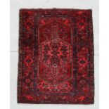 A Persian Hamadan rug with central floral medallion on a red ground within a multi border, 198 by
