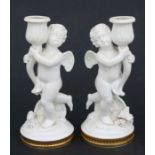A pair of Vista Alegre Portuguese porcelain figural candlesticks depicting cherubs, 21cms high (2).
