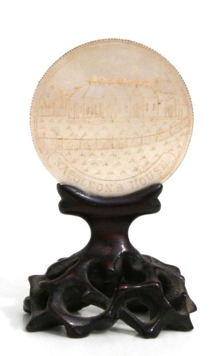 A Chinese circular mother of pearl gaming counter carved with a scene of Napoleon's House and