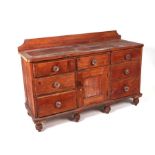 A Victorian pine dresser base with an arrangement of seven drawers and central cupboard, with