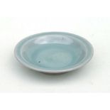 A Chinese celadon glazed shallow footed dish, 28cms diameter.
