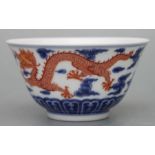 A Chinese blue, white and red footed bowl decorated with dragons amongst clouds chasing a flaming