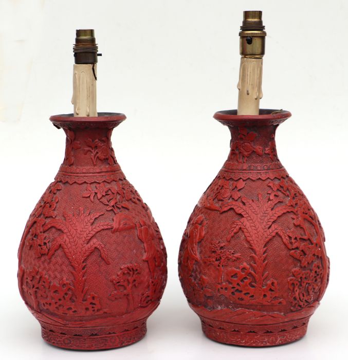 A pair of Chinese cinnabar lacquer baluster vases decorated with figures in a landscape, converted