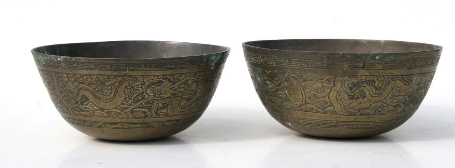 Two Chinese brass bowls decorated with scrolling dragons, six character marks to the underside,