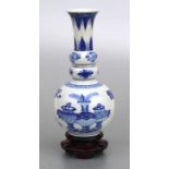 A Chinese blue & white triple gourd vase decorated with vases, on a hardwood stand, 20cms high.