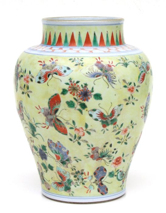 A Chinese famille rose baluster vase decorated with butterflies on a pale yellow ground, 26cms