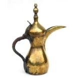 A Persian / Islamic brass dallah coffee pot with pelican shaped spout, 38cms high.