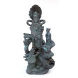 A Chinese patenated bronze / brass figural group depicting Guanyin with a child and a coiled dragon,