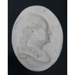An oval wall hanging plaster cast depicting a Classical male figure in profile, 44cms wide.